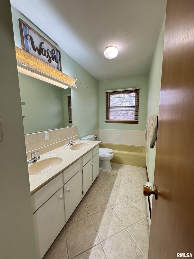 bathroom with tile patterned flooring, vanity, toilet, and a tub