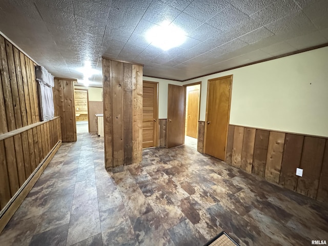 empty room with crown molding and wooden walls