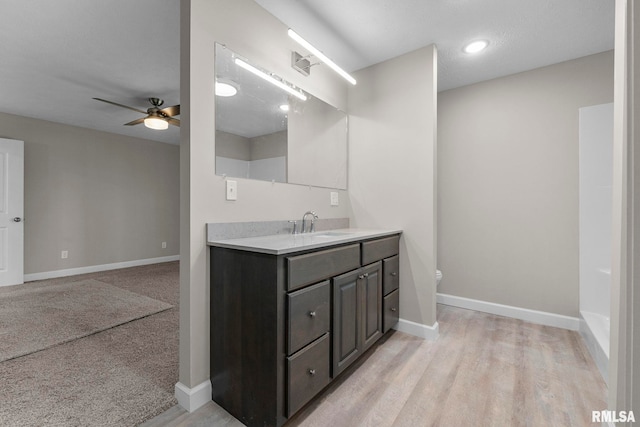 bathroom featuring ceiling fan, vanity, hardwood / wood-style flooring, and toilet