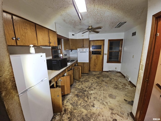 kitchen featuring brown cabinetry, light countertops, white appliances, and visible vents