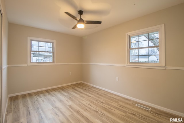 spare room with light hardwood / wood-style floors, ceiling fan, and a healthy amount of sunlight