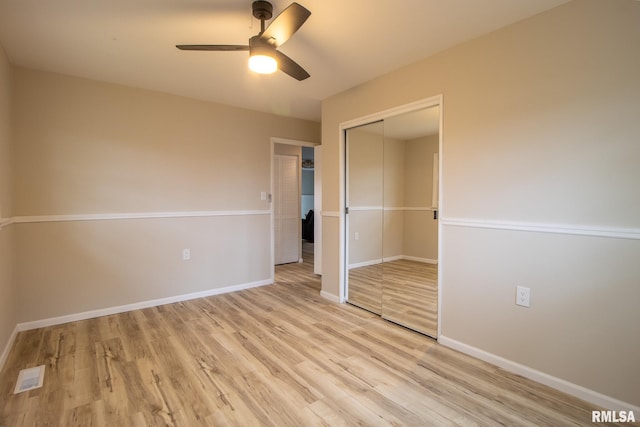 unfurnished bedroom featuring ceiling fan, light hardwood / wood-style floors, and a closet