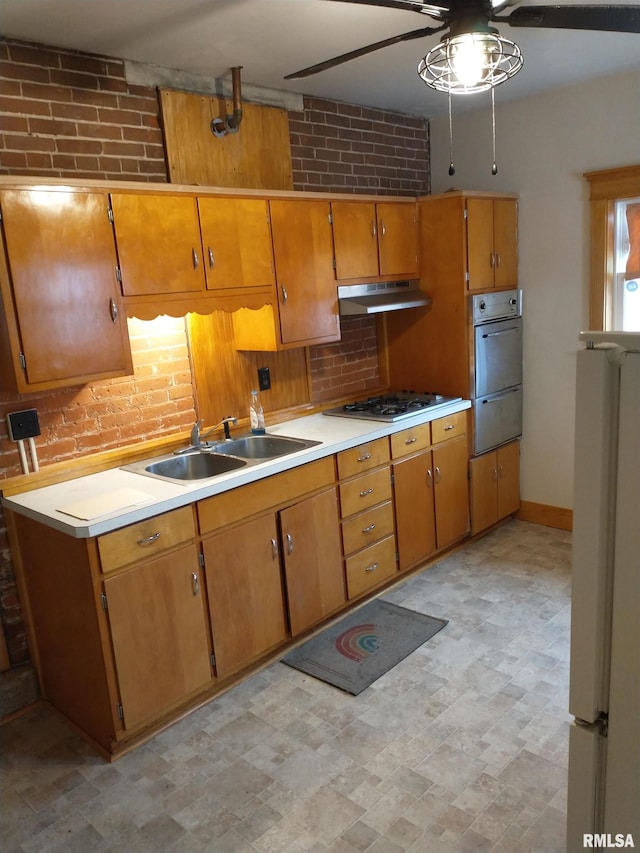 kitchen featuring sink, white gas stovetop, ceiling fan, and brick wall