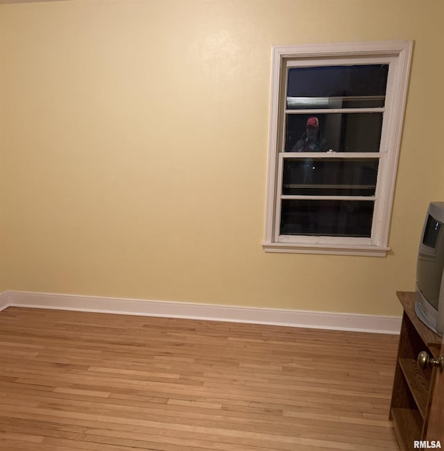 unfurnished room featuring built in features and light hardwood / wood-style flooring