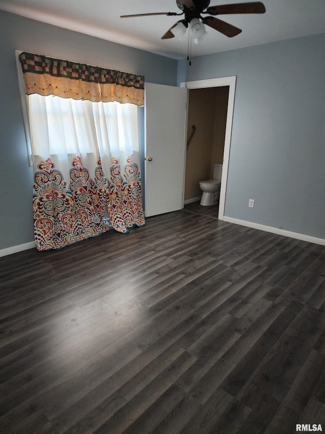 unfurnished bedroom with connected bathroom, dark hardwood / wood-style floors, and ceiling fan