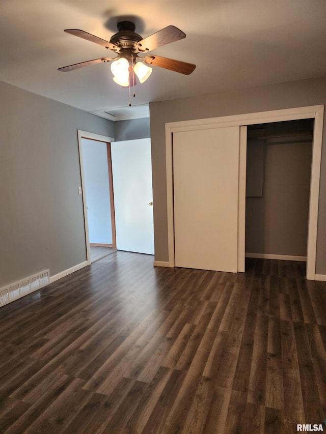 unfurnished bedroom with ceiling fan and dark wood-type flooring