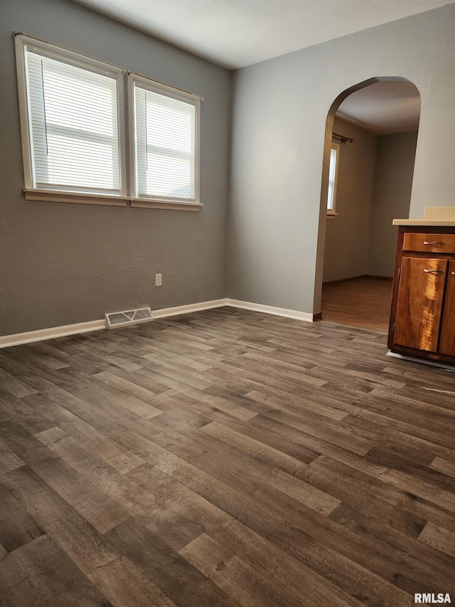 unfurnished room with dark wood-type flooring