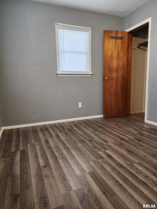 unfurnished bedroom featuring dark wood-type flooring and a closet