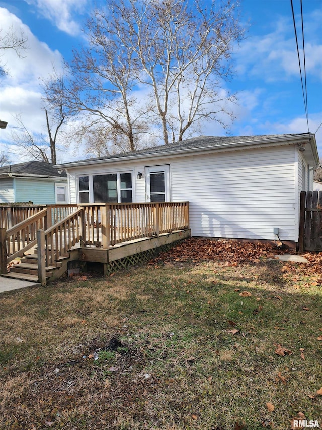 rear view of house with a lawn and a deck