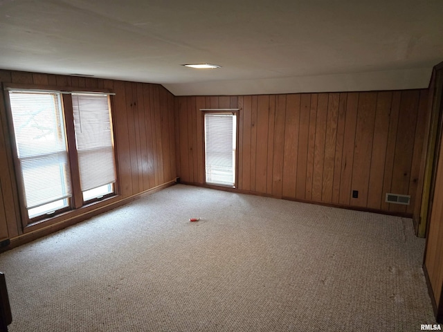 carpeted empty room with wooden walls