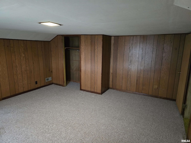 interior space with light carpet, a closet, and vaulted ceiling