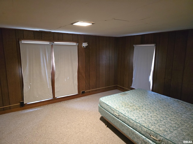 carpeted bedroom featuring wood walls