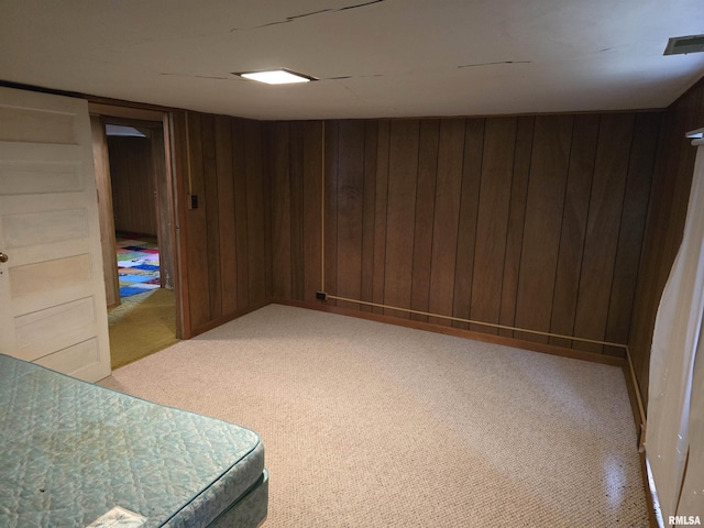 basement with carpet and wood walls