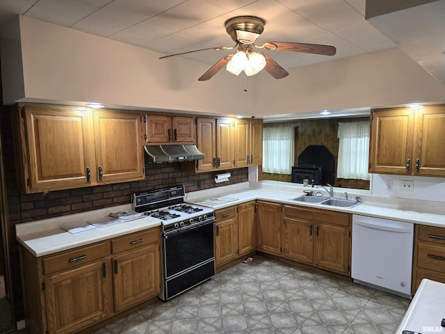 kitchen featuring backsplash, white dishwasher, sink, ceiling fan, and gas stove