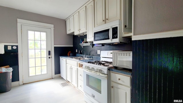 kitchen featuring white cabinetry, sink, and white appliances