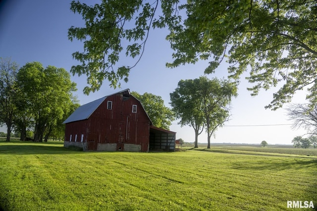 view of outdoor structure featuring a rural view and a yard