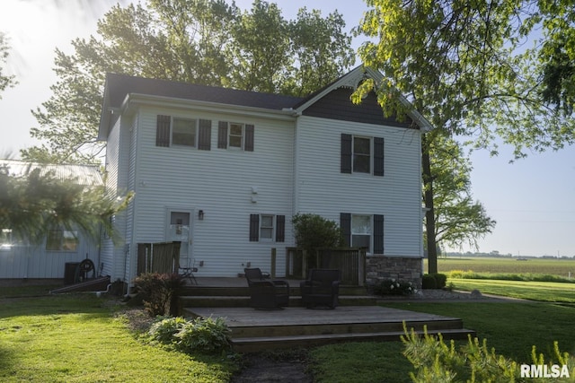 rear view of house with a deck and a yard