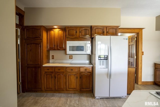 kitchen with white appliances and light hardwood / wood-style floors