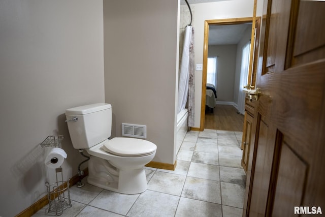 bathroom with tile patterned floors, toilet, and shower / bath combo with shower curtain