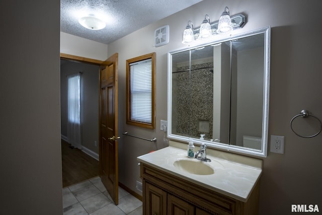 bathroom with vanity, a textured ceiling, and tile patterned floors