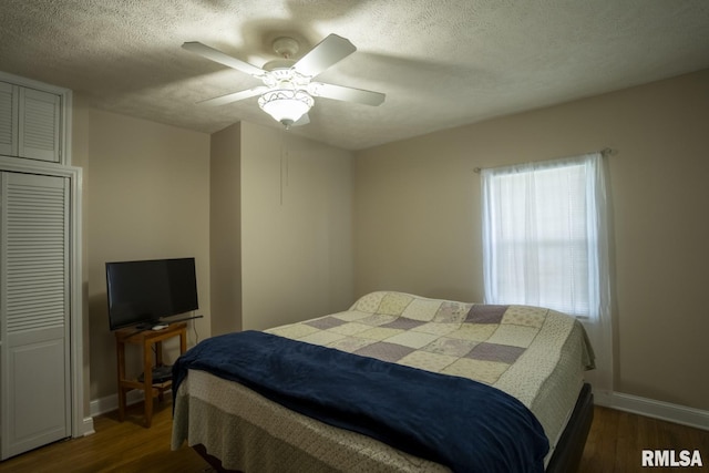 bedroom featuring ceiling fan, dark wood-type flooring, and a textured ceiling