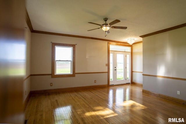 empty room featuring hardwood / wood-style floors, plenty of natural light, ceiling fan, and crown molding