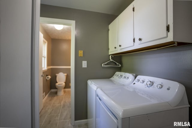 laundry room with washing machine and clothes dryer and cabinets