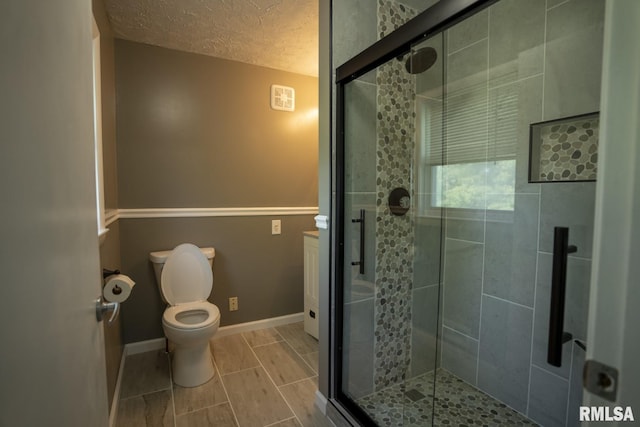 bathroom with toilet, a textured ceiling, and walk in shower