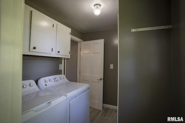 clothes washing area with washing machine and dryer and cabinets