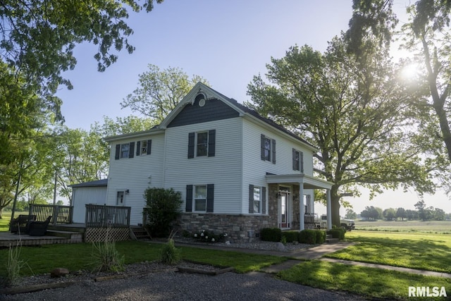 view of front of home featuring a front lawn and a wooden deck