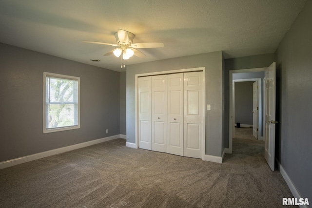 unfurnished bedroom with carpet, ceiling fan, a textured ceiling, and a closet