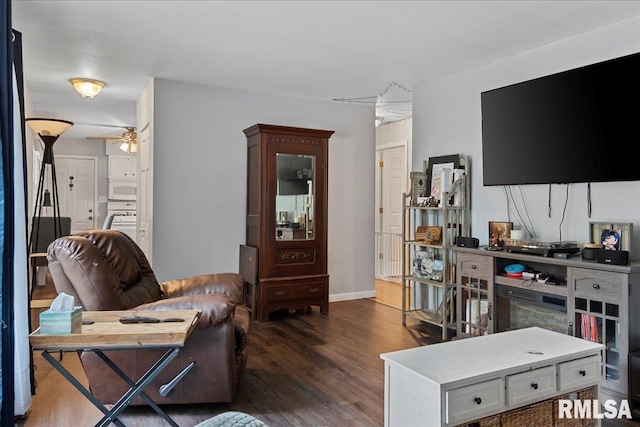 living room with dark hardwood / wood-style flooring and ceiling fan