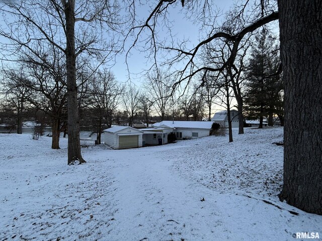 yard layered in snow with a garage