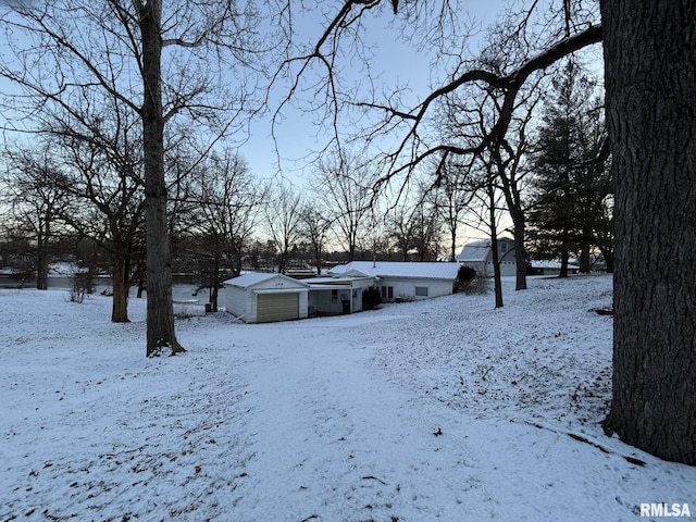 snowy yard with an outbuilding