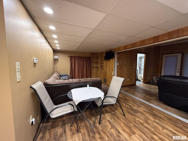 cinema room featuring ceiling fan, hardwood / wood-style floors, and wooden walls