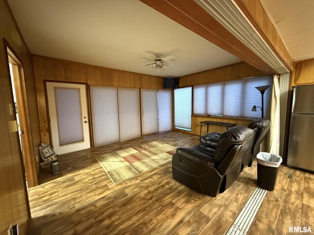 living room featuring wood-type flooring, sink, and wooden walls