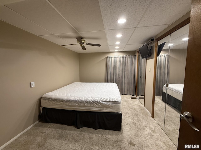 carpeted bedroom with a ceiling fan, recessed lighting, a drop ceiling, and baseboards