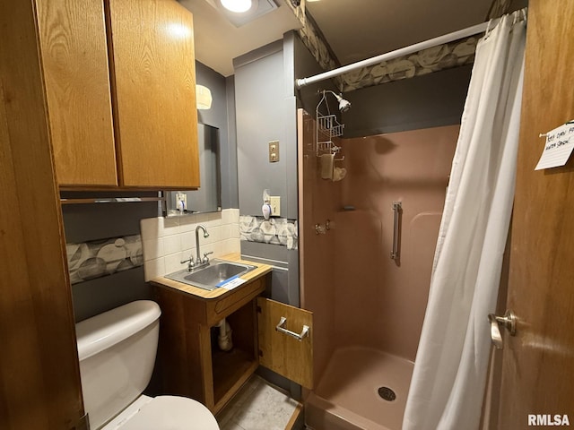 full bath featuring tasteful backsplash, a sink, toilet, and a shower stall