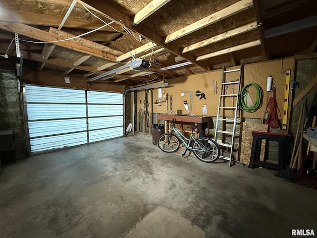 garage with a workshop area and a garage door opener