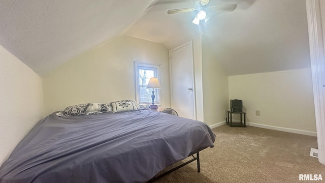 carpeted bedroom featuring ceiling fan, vaulted ceiling, and a textured ceiling