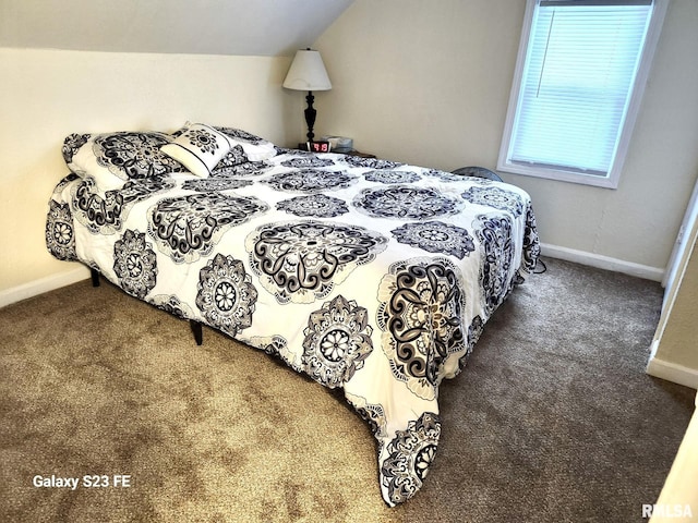 bedroom with lofted ceiling and dark colored carpet