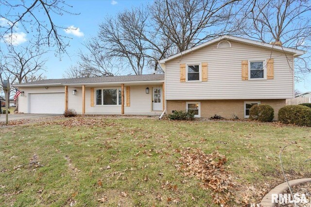 tri-level home featuring a front lawn and a garage