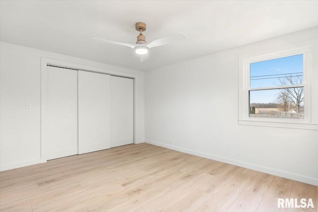 unfurnished bedroom with ceiling fan, a closet, and light hardwood / wood-style flooring