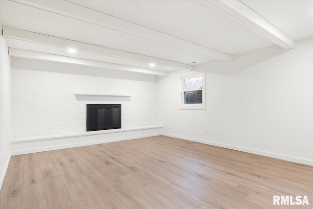 basement with light wood-type flooring and a fireplace