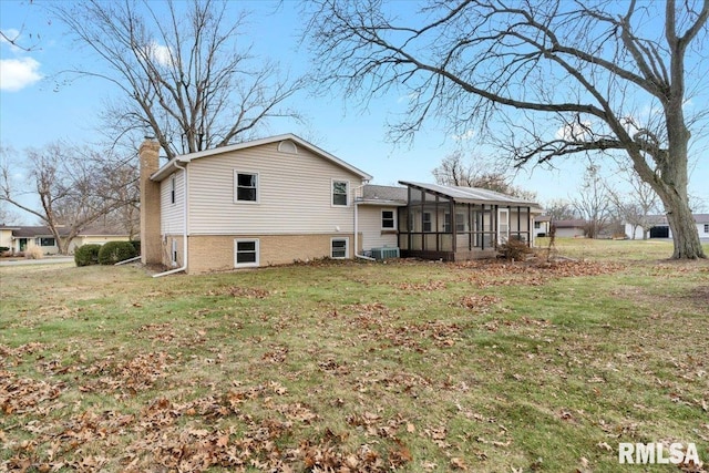 view of home's exterior featuring a sunroom, cooling unit, and a lawn