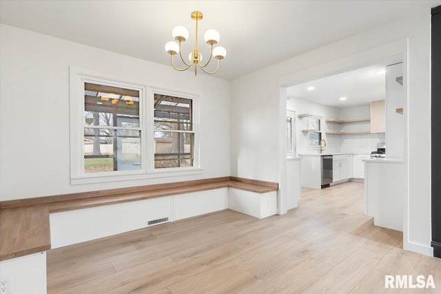 unfurnished dining area with a chandelier, light wood-type flooring, and beverage cooler