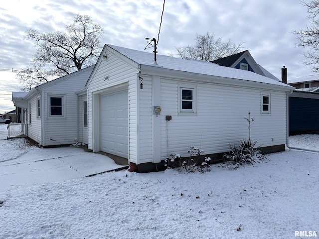 snow covered property featuring a garage