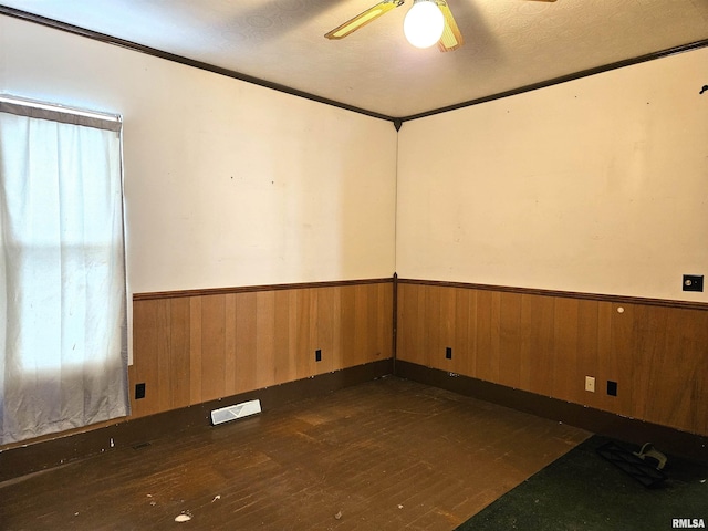 unfurnished room with a textured ceiling, dark hardwood / wood-style floors, ceiling fan, and ornamental molding