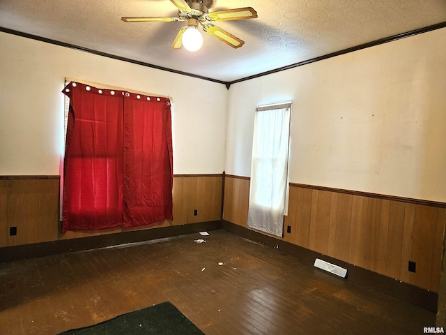 unfurnished room with crown molding, ceiling fan, dark hardwood / wood-style floors, and a textured ceiling