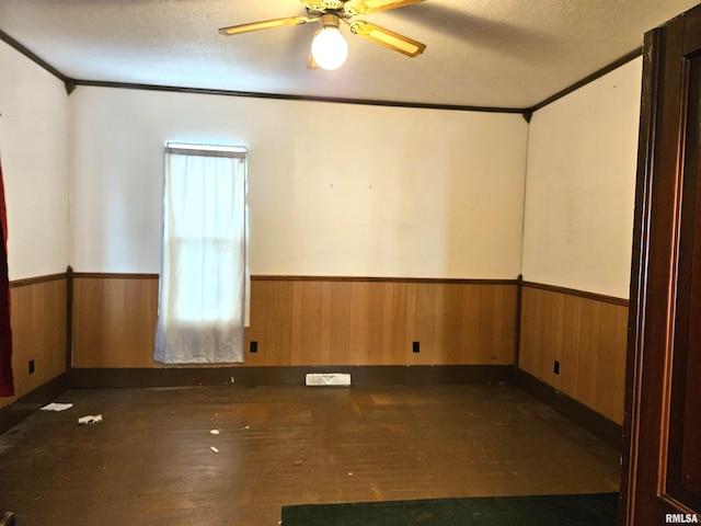 spare room with ceiling fan, crown molding, a textured ceiling, and dark wood-type flooring